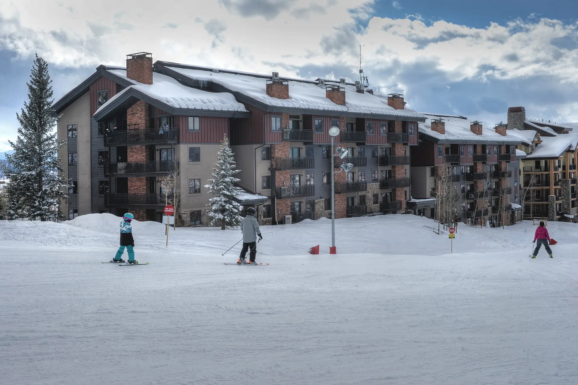 People skiing in front of a rental property in Bear Claw