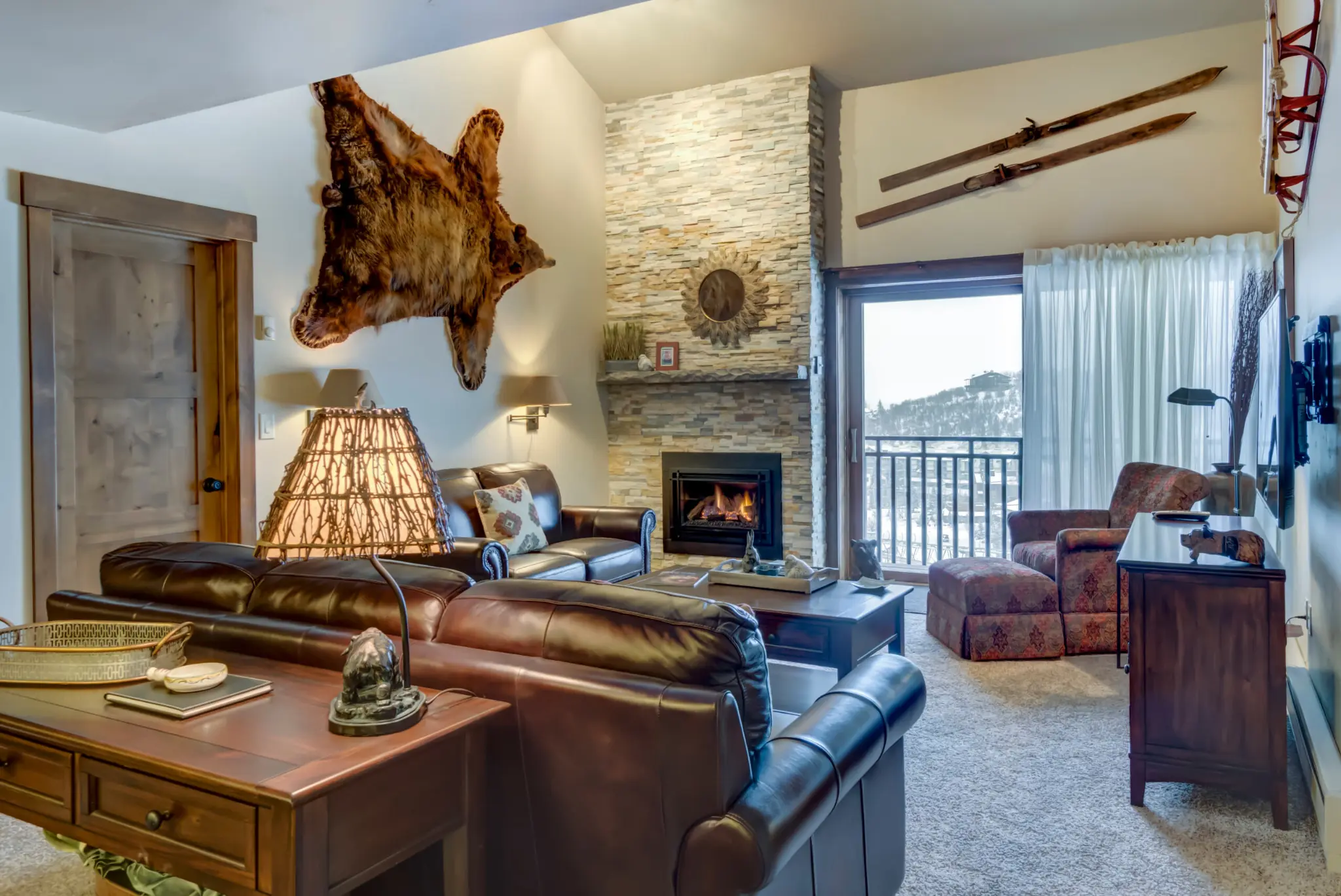Living room including fireplace, bearskin, and balcony overlook